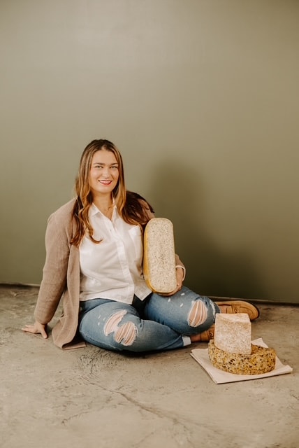 Hailey Hicks, founder of Hicks Family Creations, holding artisan cheese